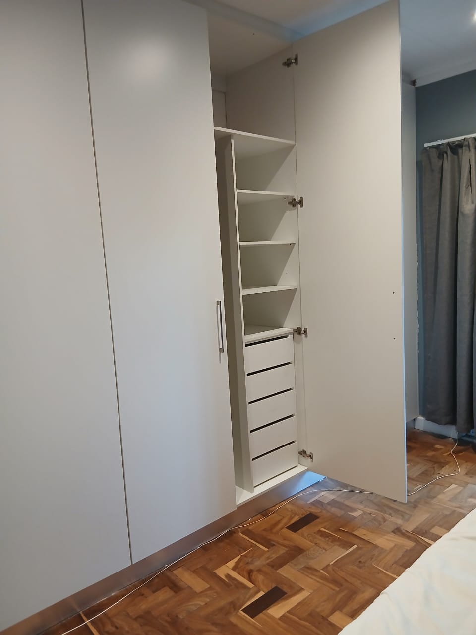 Open fitted wardrobe with drawers and shelving